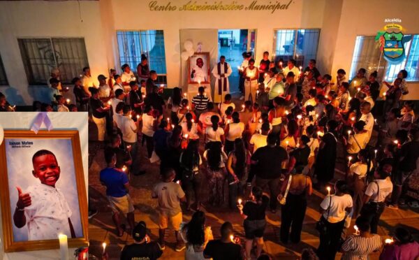 Personas con velas en las manos y reunidas en la sede del municipio de Bahía Solano, rezan por un niño fallecido durante el sismo, en Colombia. Era hijo del alcalde.