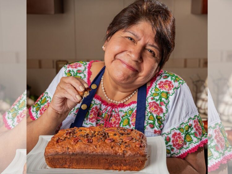 Abue Angie posa con su libro Recetario para mis nietecitos independientes durante una entrevista en la que relata cómo inició su trayectoria como creadora de contenido y promotora de la cocina casera.