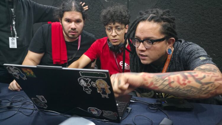Joven universitario edita un cortometraje en una computadora portátil frente a un monitor grande durante el Rally Universitario del GIFF.