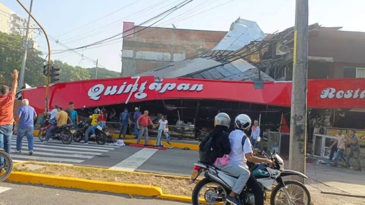Fotografía que documenta los daños materiales causados por el reciente sismo de magnitud 7.4 en Colombia. Muestra la fachada y el techo de lámina colapsados del restaurante Quintapan, con varias personas evaluando los estragos en la vía pública.