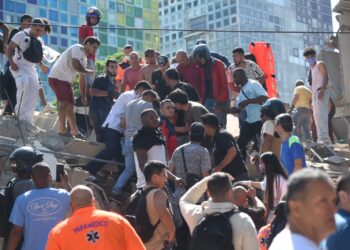 Ciudadanos y personal de emergencia realizan labores de rescate entre los escombros de un edificio colapsado tras el terremoto en Cali, Colombia.