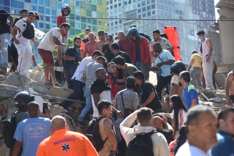 Ciudadanos y personal de emergencia realizan labores de rescate entre los escombros de un edificio colapsado tras el terremoto en Cali, Colombia.