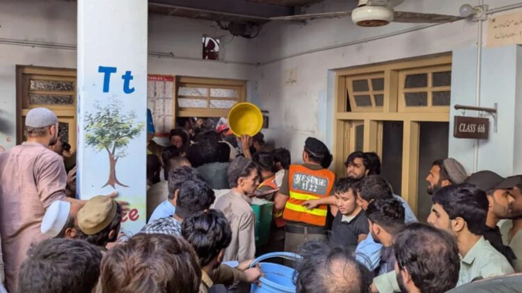 Rescatistas y voluntarios buscan a personas debajo de los restos de un techo de escuela que colapsó, en Pakistán.