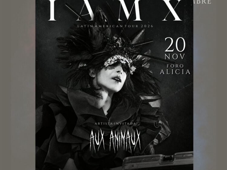 Chris Corner, líder de IAMX, durante una presentación en vivo con una puesta en escena de estética oscura, iluminación teatral y elementos audiovisuales.