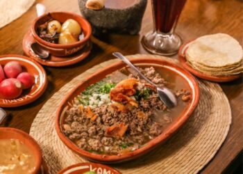 Platillo tradicional de carne en su jugo al estilo de Guadalajara, preparado con trozos de res, tocino y frijoles, acompañado de cebolla, cilantro, rábanos y limón.