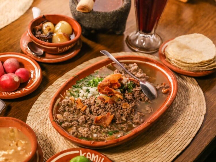 Platillo tradicional de carne en su jugo al estilo de Guadalajara, preparado con trozos de res, tocino y frijoles, acompañado de cebolla, cilantro, rábanos y limón.