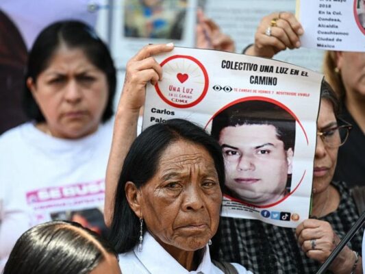 Familiares de personas desaparecidas muestran fotografías de sus seres queridos y exigen verdad y justicia.