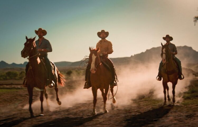 Tres hermanos de “Tierra de Amor y Coraje” montan a caballo en un paisaje de rancho